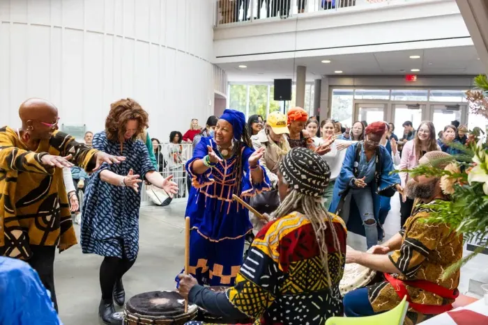 Drummers and dancers joyfully performing in the Campus Center.